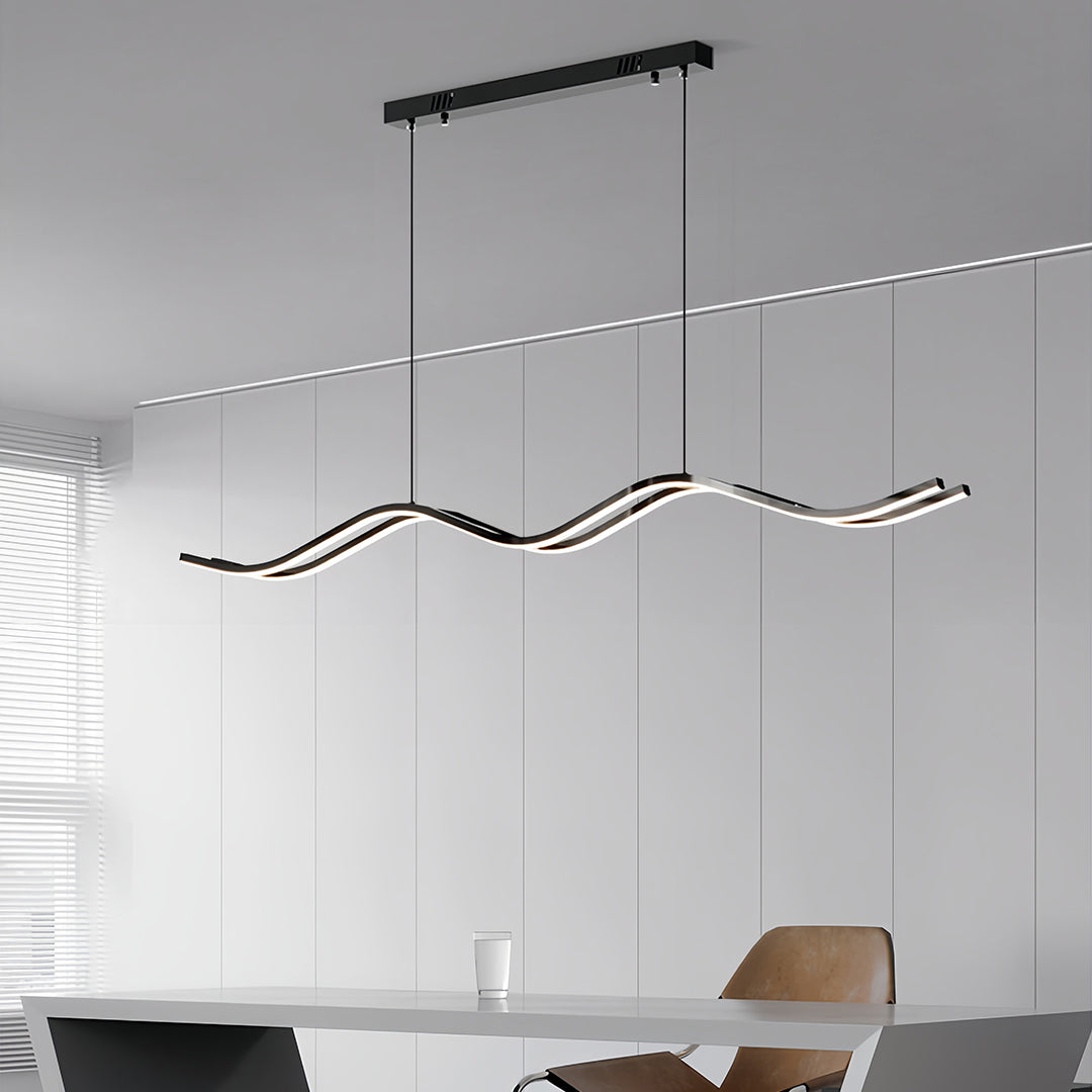 Suspended black kitchen island pendant light providing sleek, modern task lighting over a dining table in a contemporary minimalist space.