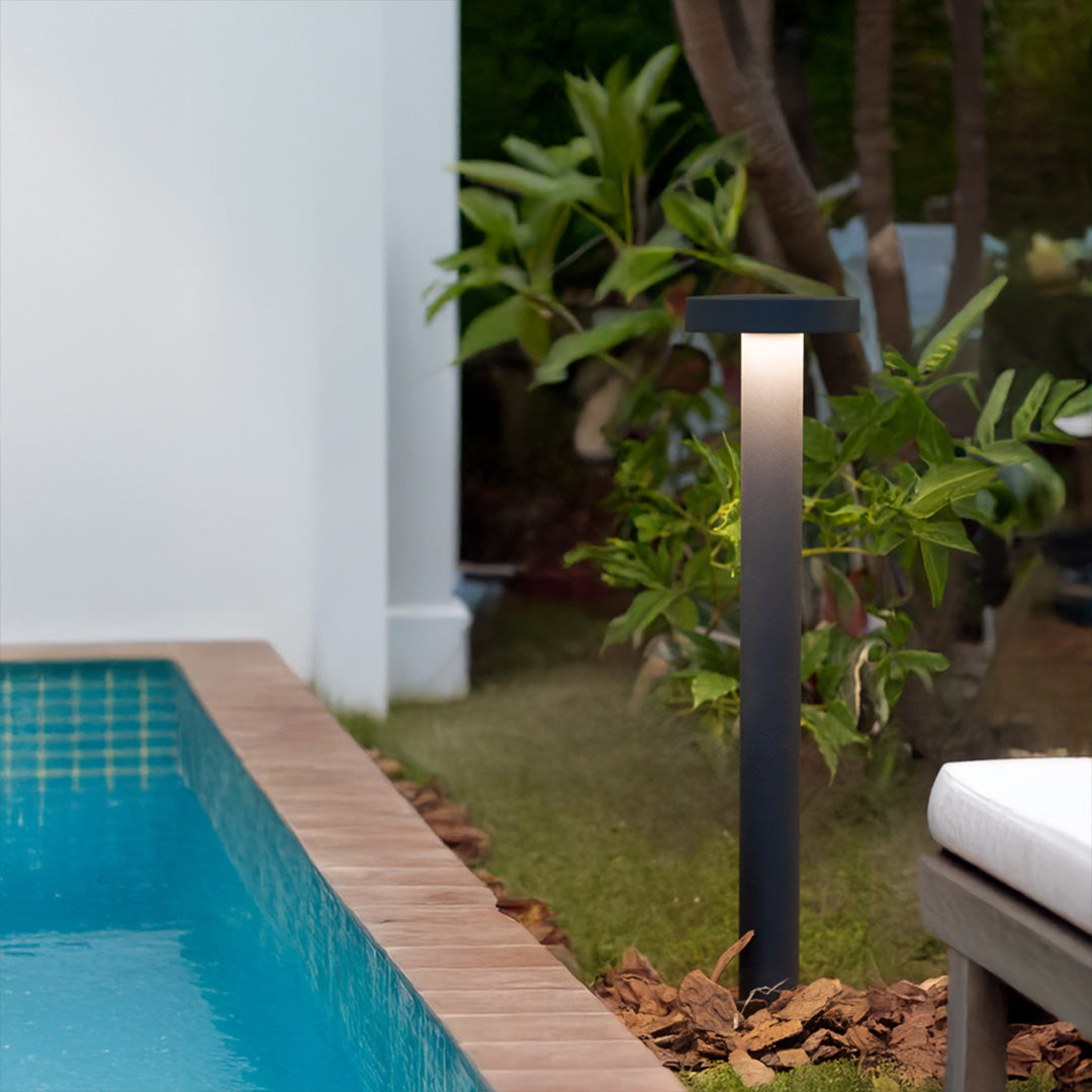 Modern LED path light positioned near swimming pool with contemporary outdoor living space design