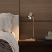 Swing arm desk lamp placed on bedside table, creating warm ambient lighting.