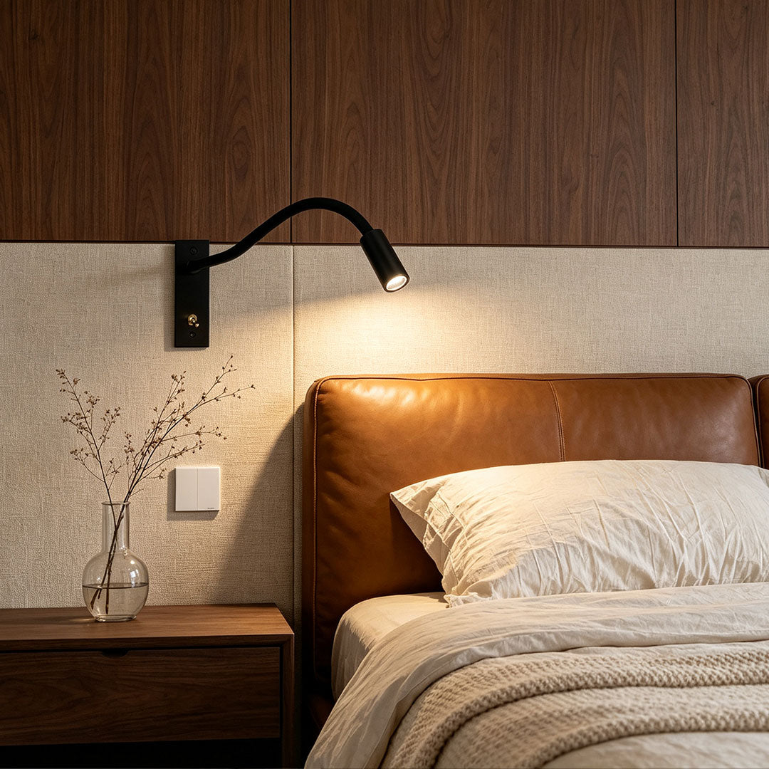 Modern swing arm wall mount light installed beside a cozy upholstered bedroom bed.