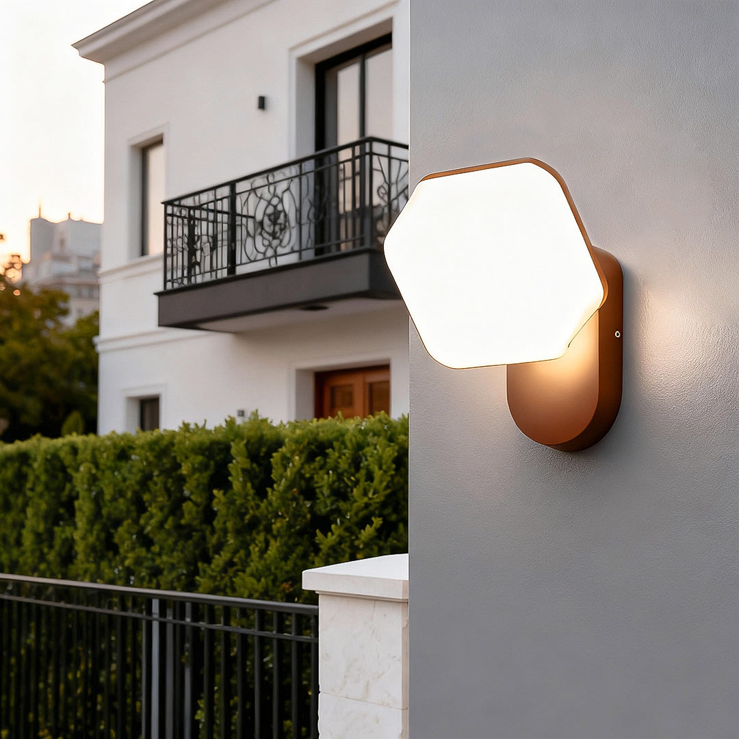 Matte white swing wall light in hexagon form with soft shadowing, designed for minimal modern interiors.