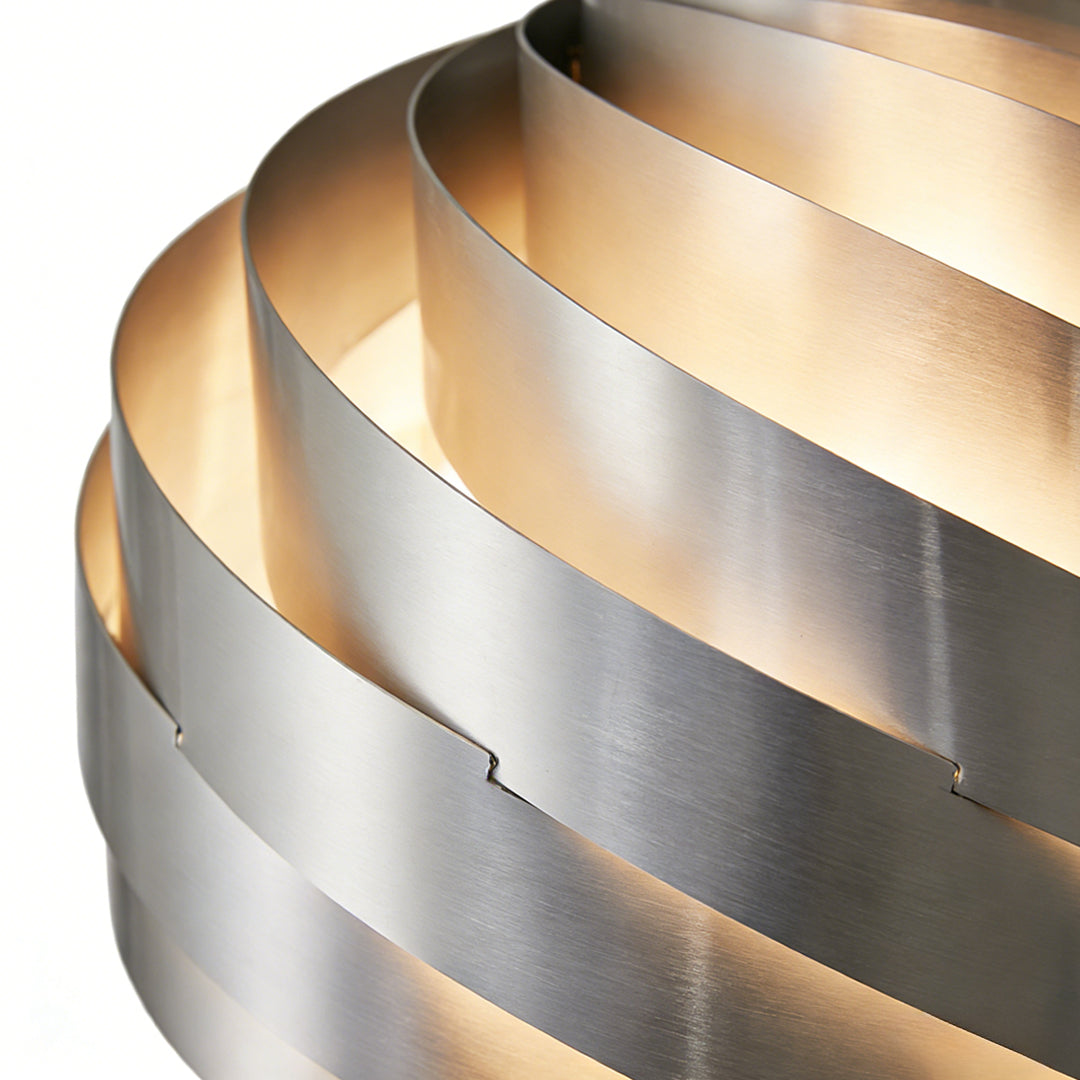 Angled detail of a swirl pendant light highlighting spiral metal ribbons with soft ambient glow and contemporary decorative style.