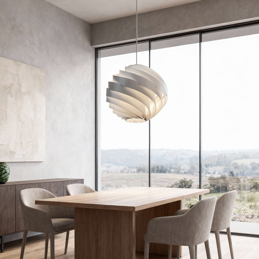 Swirl pendant light hanging above dining table in a bright modern interior.