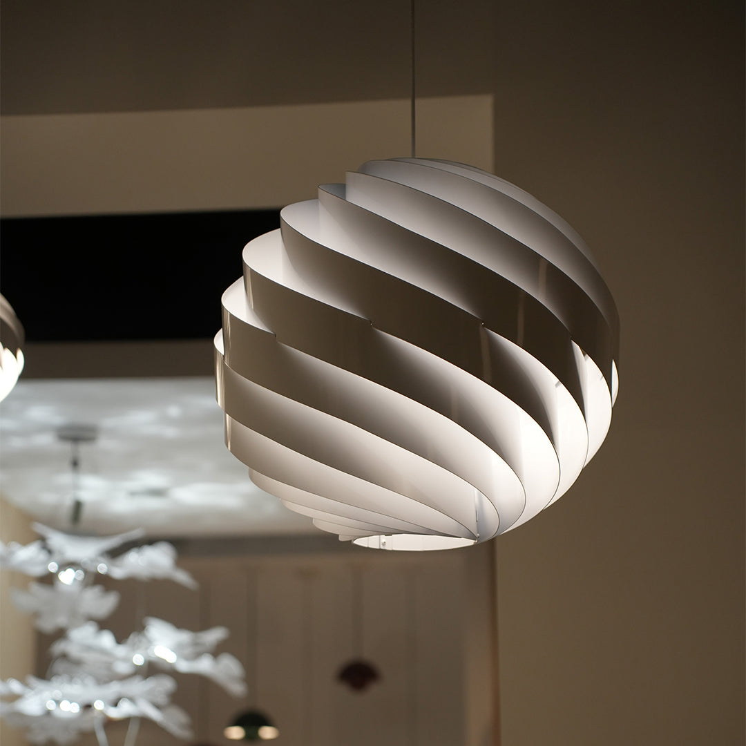 Modern swirl pendant light in cozy home interior with artistic lighting design.