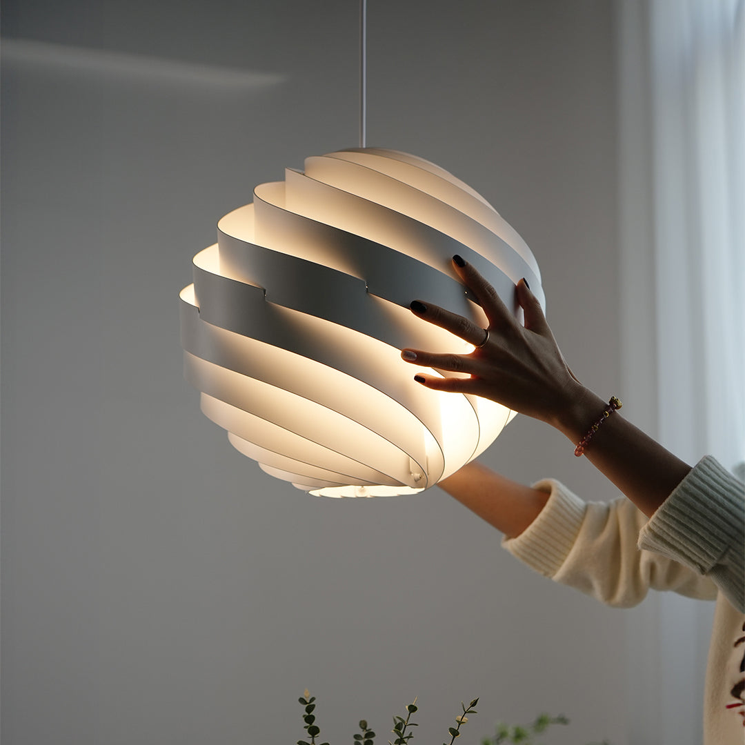 Modern swirl pendant light in cozy home interior with artistic lighting design.