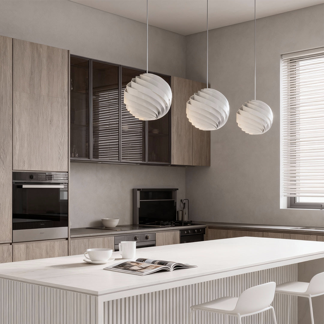 White swirl pendant lights above kitchen table with modern minimalist decor.