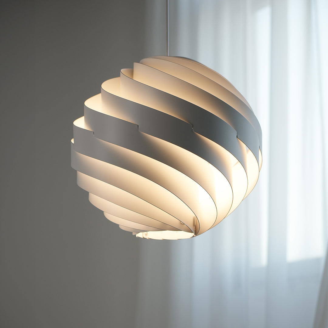 Swirl pendant light emitting warm soft light through overlapping white layers.