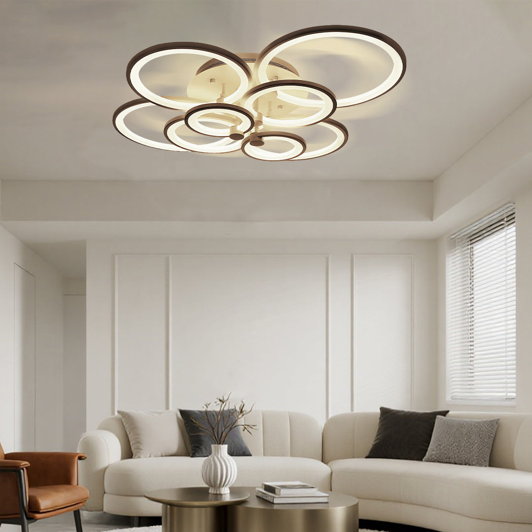 Bright modern living room illuminated by symmetrical multi ring ceiling lights in circular layout.