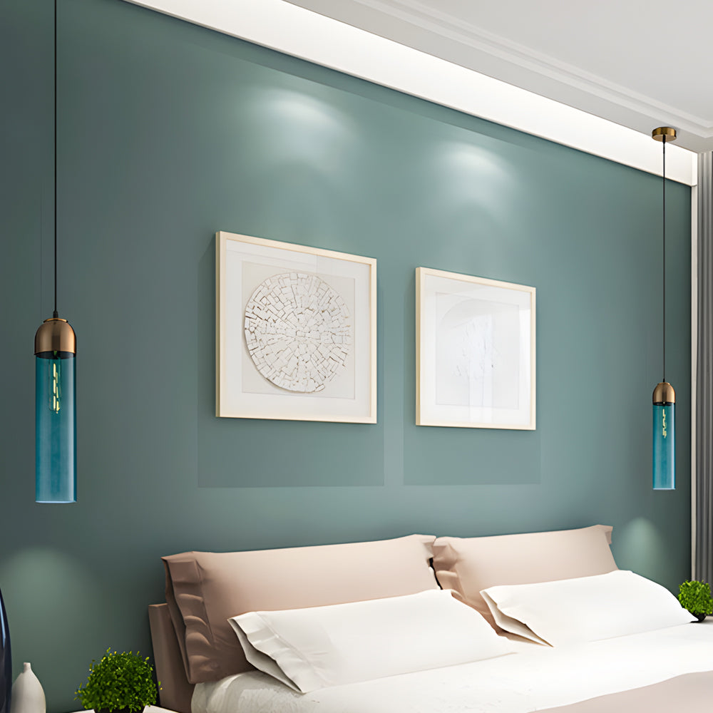 Symmetrical teal Gold Frosted Cylinder Pendant lights as bedside lamps against a green wall.