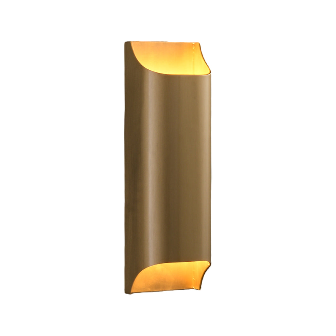 Tall brushed brass wall light fixture with a warm up and down glow isolated on a white studio.