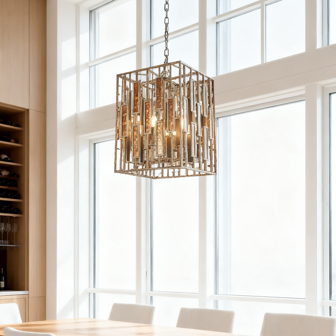 Tall vintage copper pendant light with a cage design, centered in a kitchen dining area with floor-to-ceiling windows and wood cabinetry.