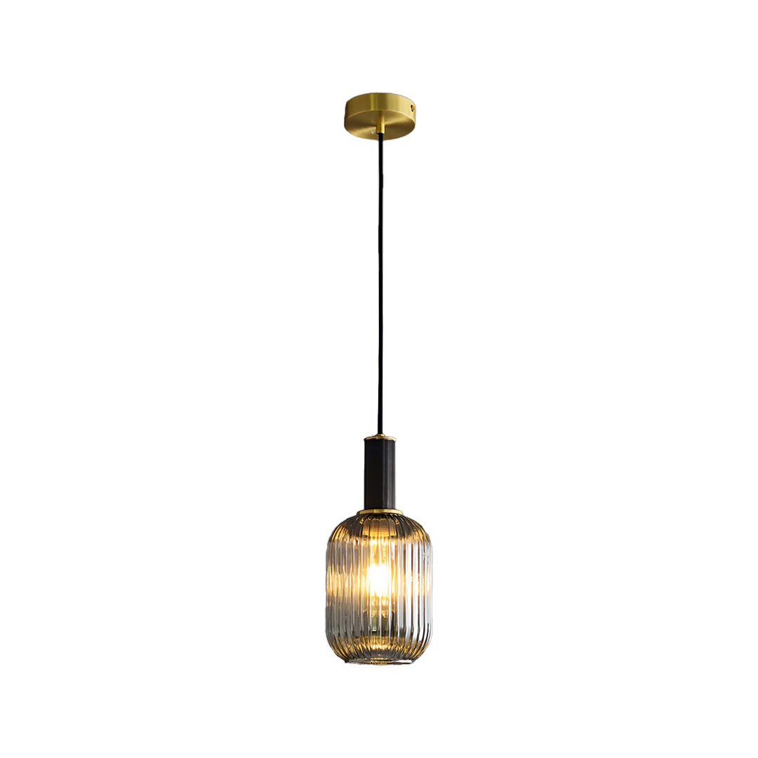 Tall cylindrical vintage glass pendant light glowing warmly isolated on a clean white background