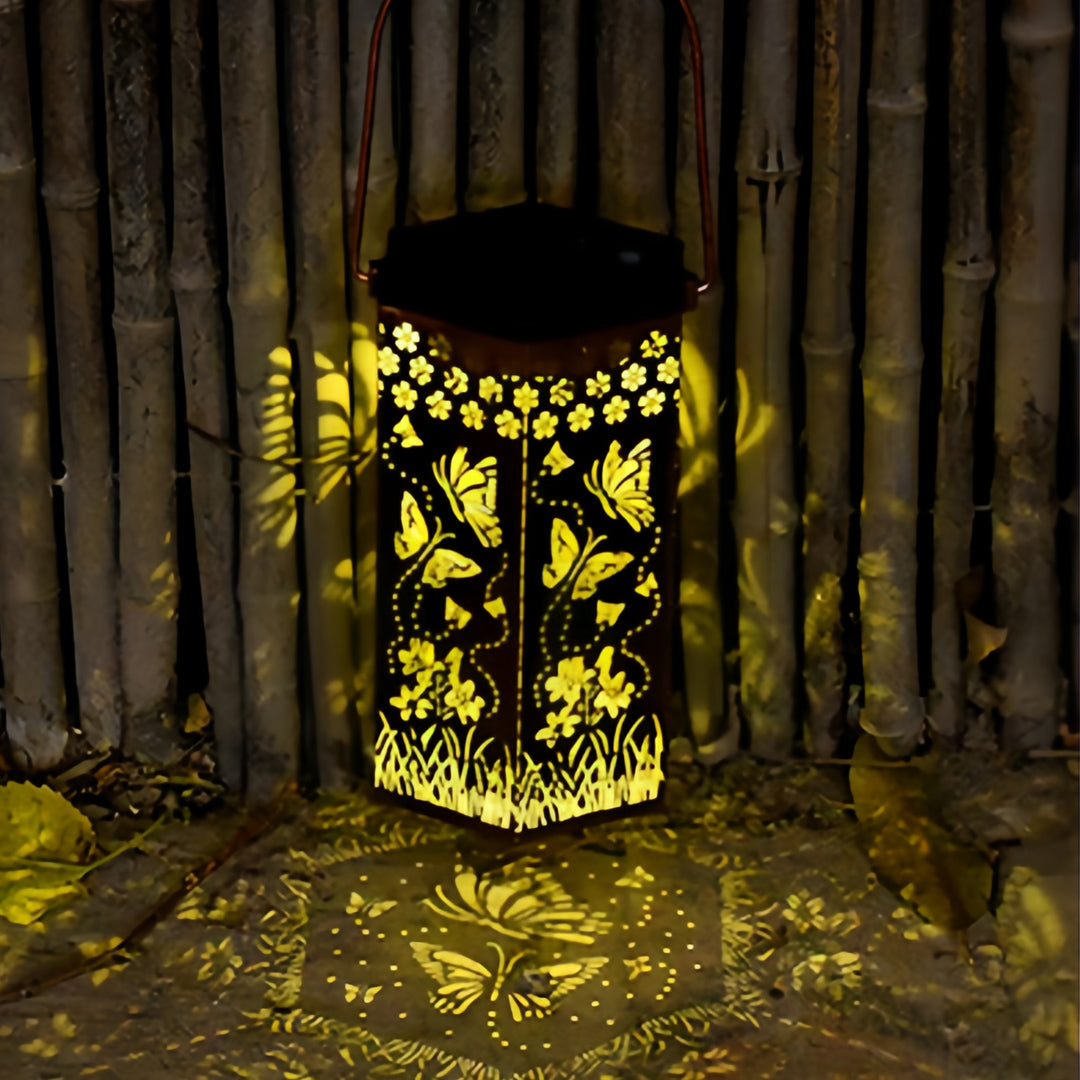Tall hexagonal red outdoor lantern placed against a bamboo fence backdrop for patio accent lighting.