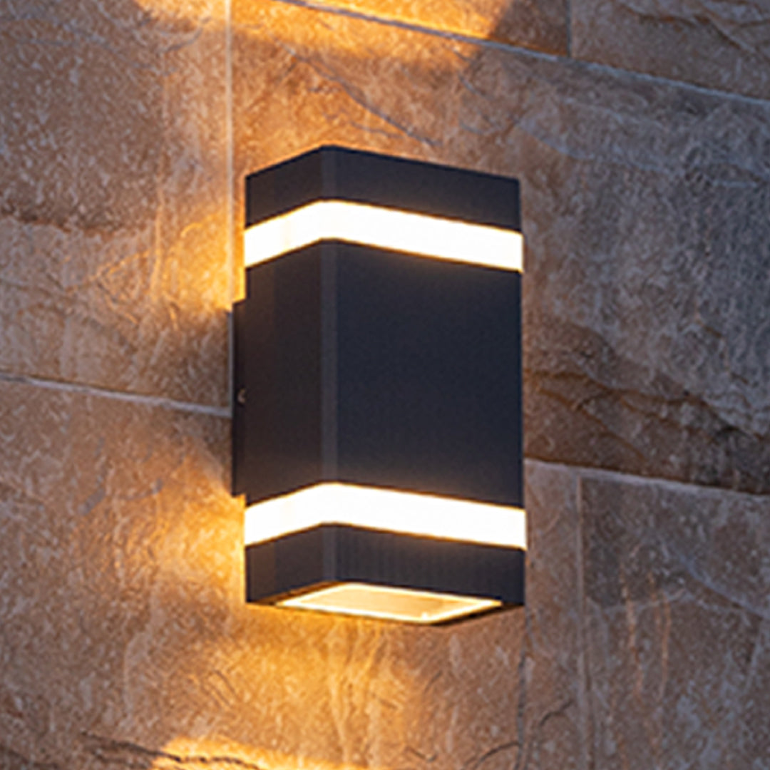 Tall rectangular black garden wall light with two white stripes on grey stone