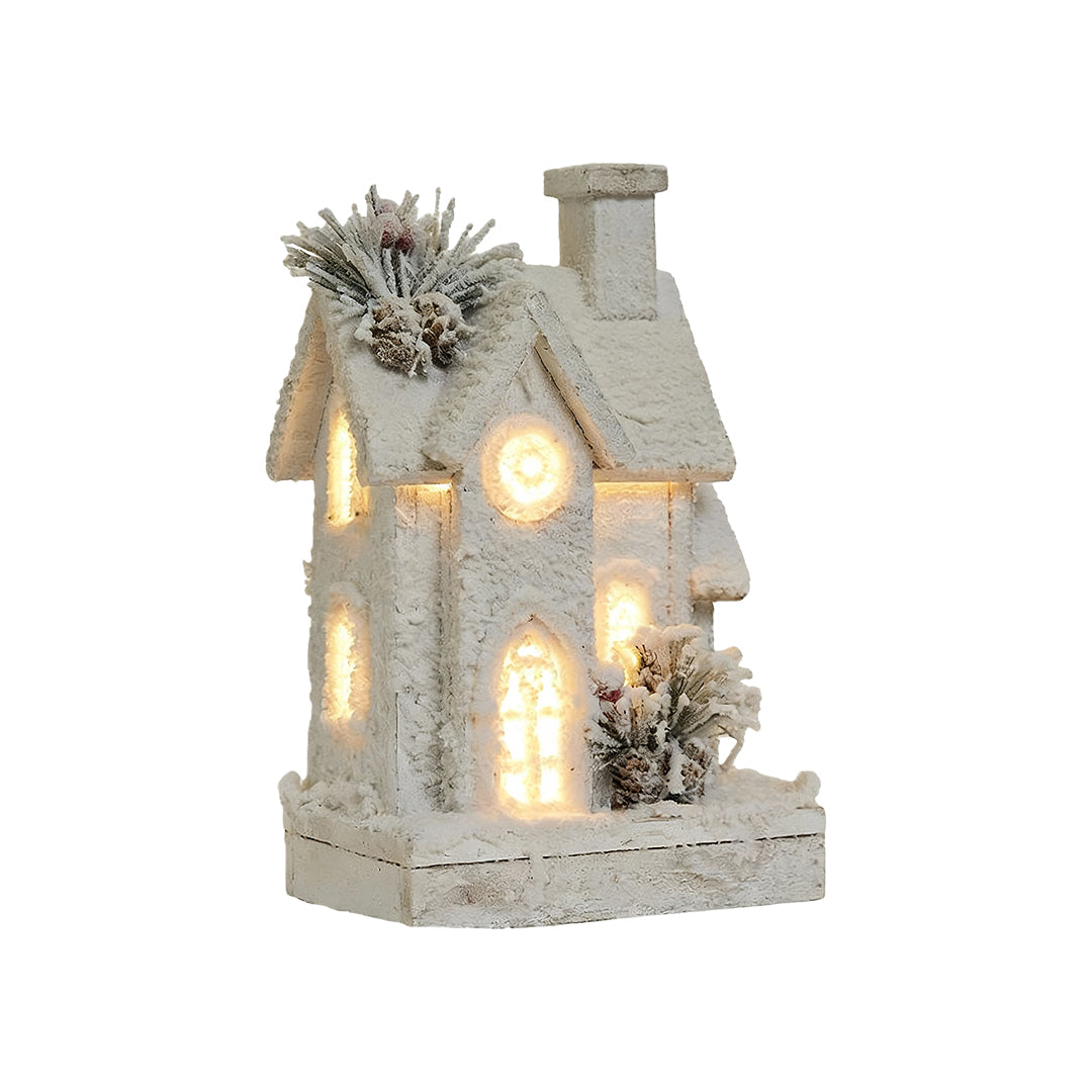 Tall wooden Christmas cottage with frosted roof, pine decor, and warm LED lighting.