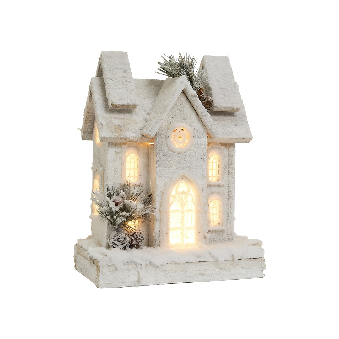 Tall wooden Christmas cottage with frosted roof, pine decor, and warm LED lighting.
