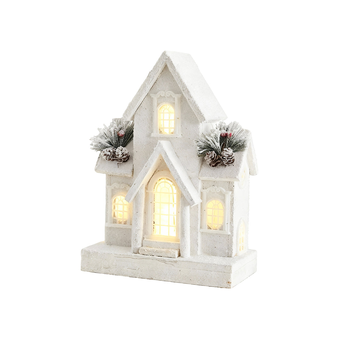 Tall wooden Christmas cottage with frosted roof, pine decor, and warm LED lighting.