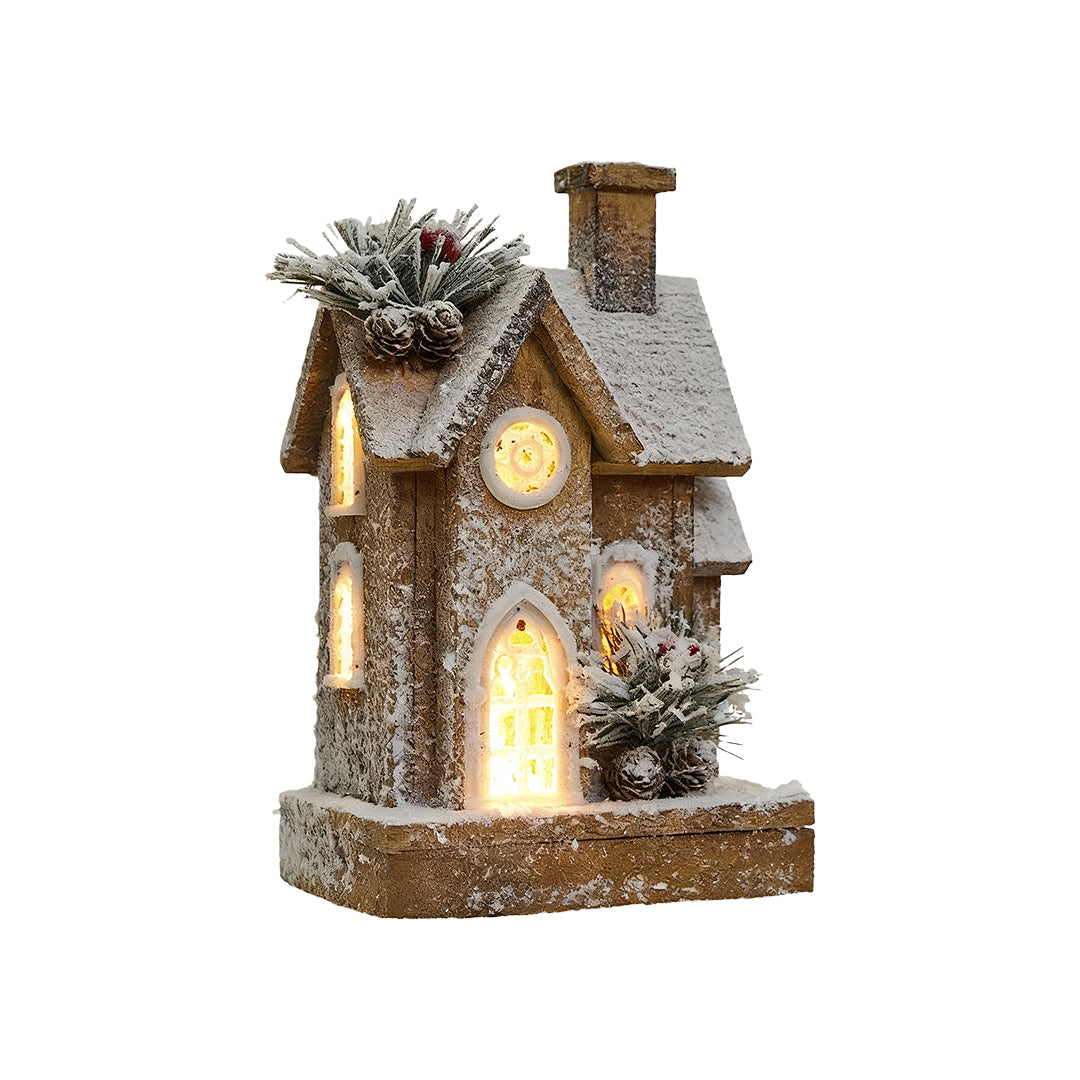 Tall wooden Christmas cottage with frosted roof, pine decor, and warm LED lighting.