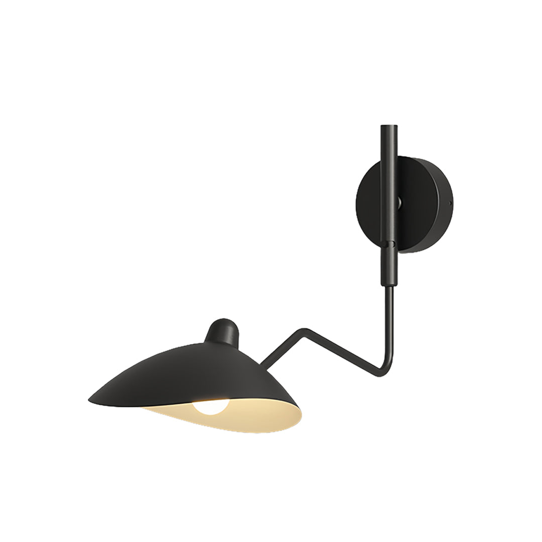 Swing arm wall light used for task lighting in a bedroom setup, complementing the dark blinds and minimalist interior design.