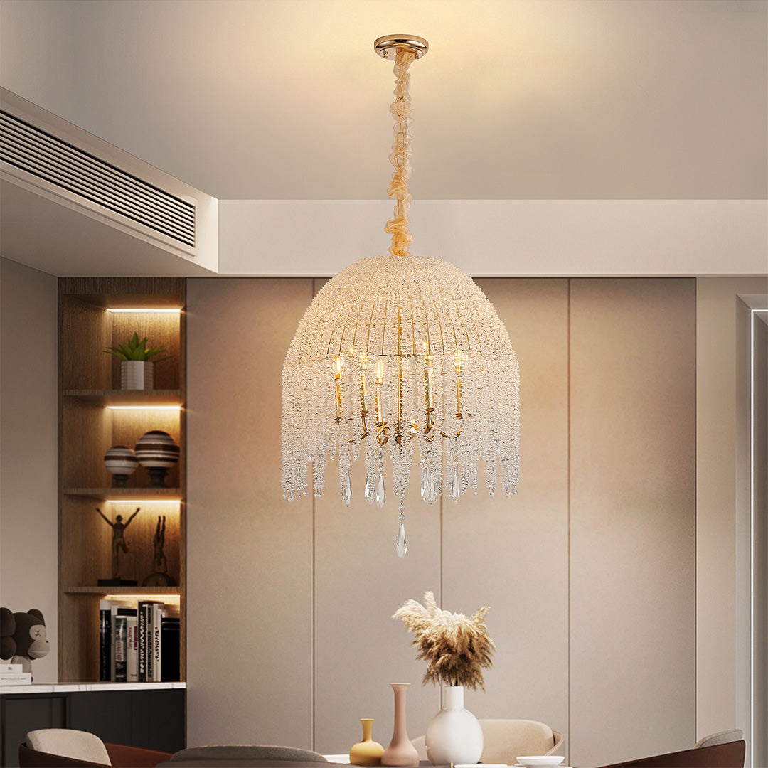 Compact gold teardrop crystal chandelier hanging above a dining table, radiating cozy sophistication.