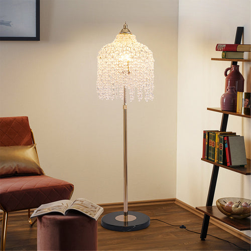 Cozy living room corner illuminated by a gold teardrop floor crystal lamp with warm ambient lighting.