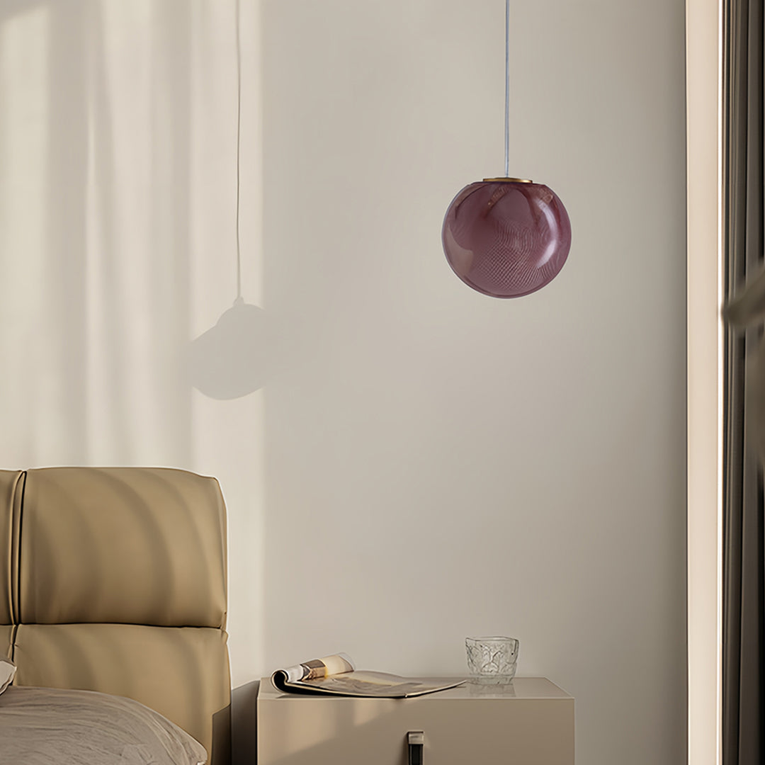 Artistic glass globe pendant lights showcasing textured amber glass surface with integrated LED technology for bedroom applications