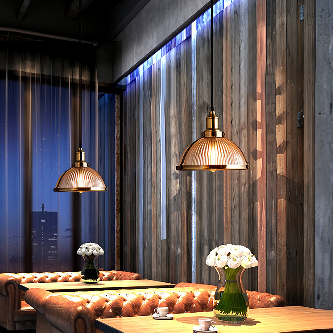 Textured glass pendant lights in modern kitchen with brass accents creating focused task lighting over workspace