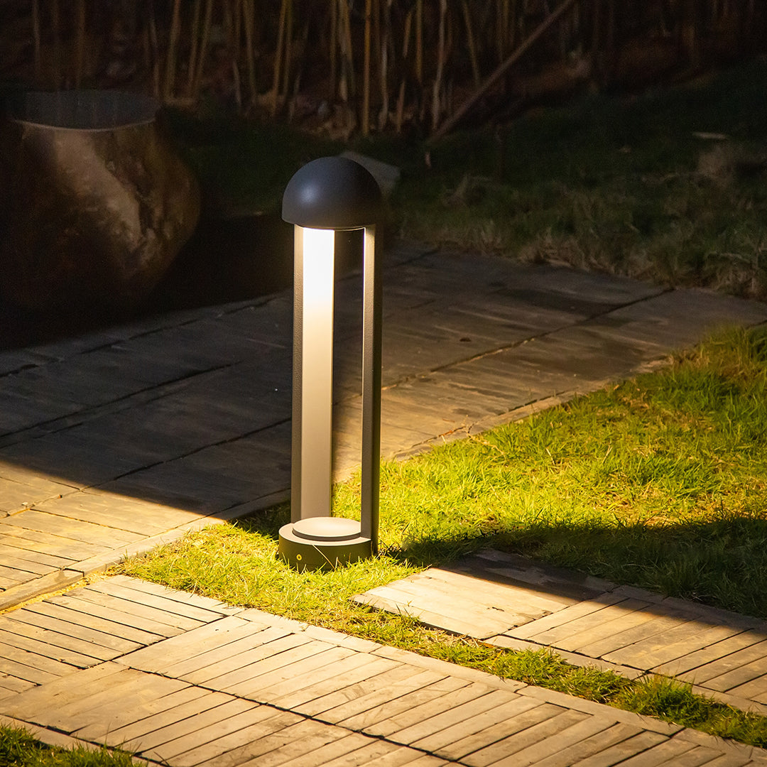 Architectural bollard lighting creating dramatic ground wash on textured paving surface