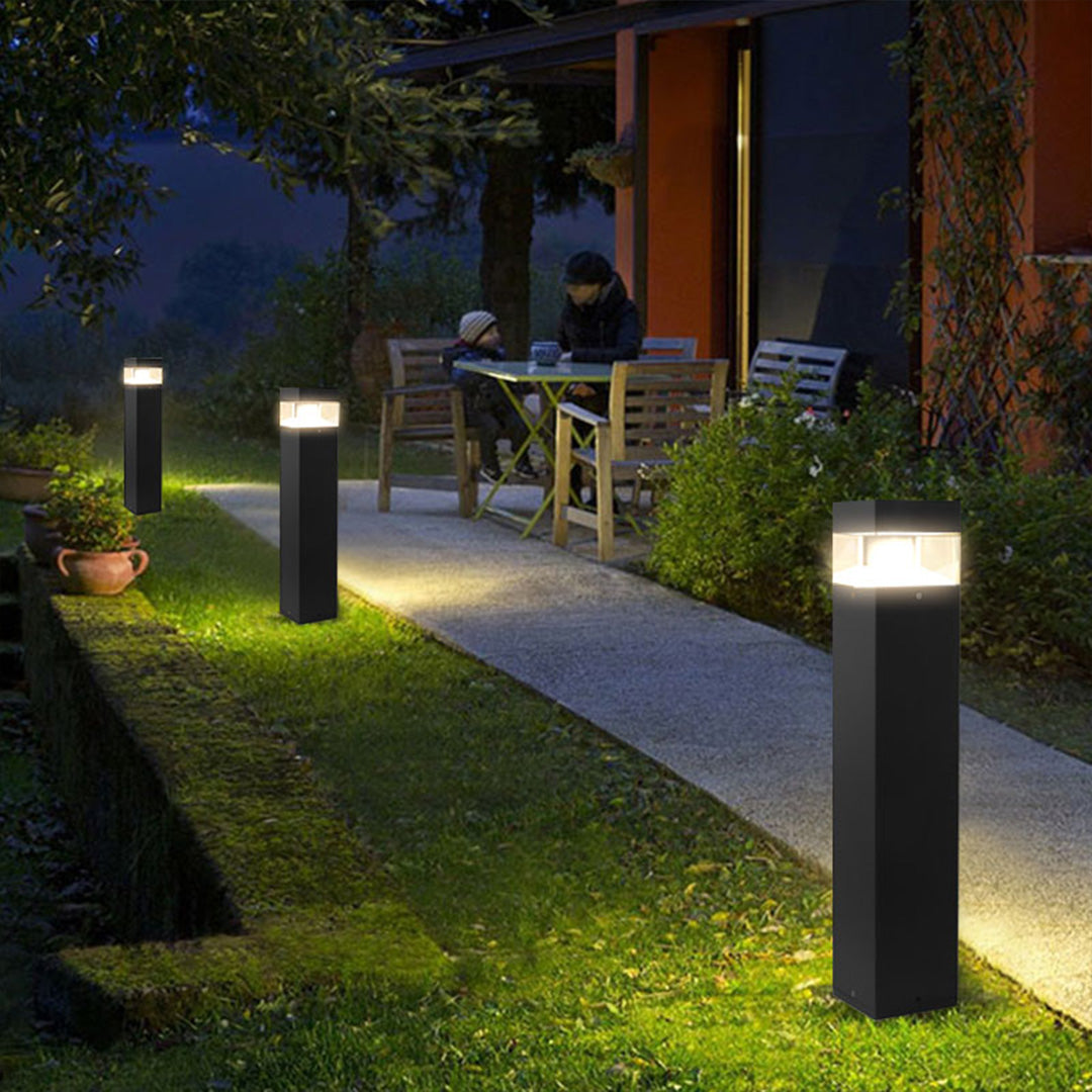 Contemporary square bollards providing pathway lighting along residential walkway at dusk