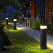 Contemporary square bollards providing pathway lighting along residential walkway at dusk