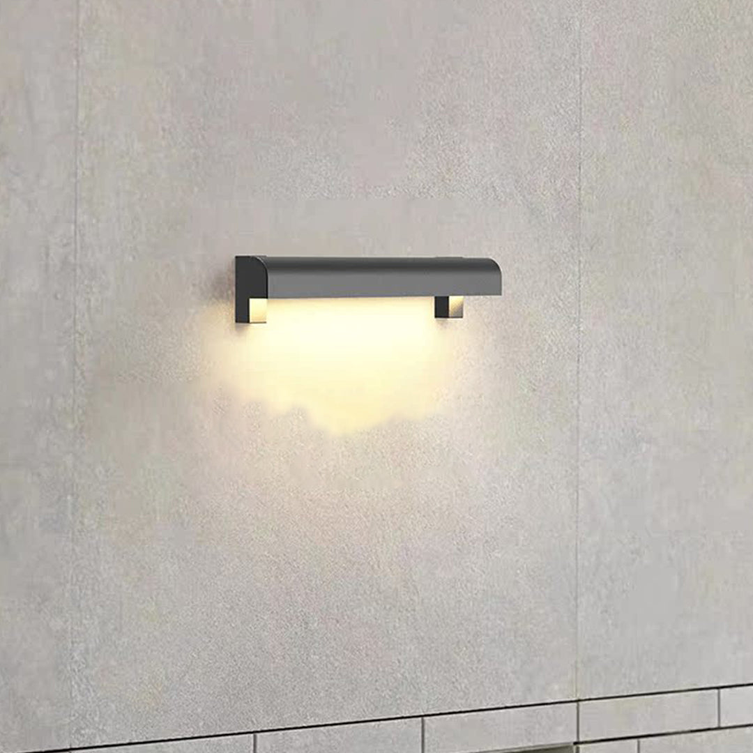 Soft illuminated outdoor wall sconce light fixtures mounted on a textured exterior wall at night.