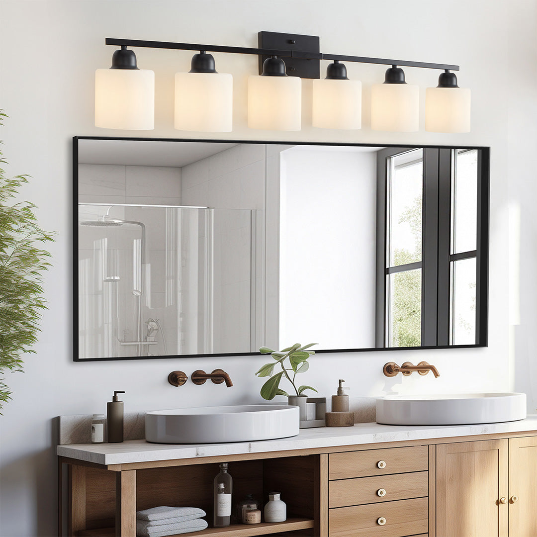 Modern bathroom vanity light with three bulbs, mounted above a white countertop and wooden cabinet.