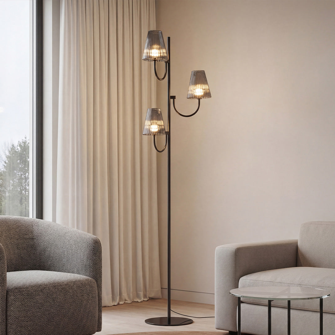 Modern 3-light black contemporary floor lamp with smoked glass shades in a chic living room corner