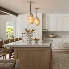 Tiered glass pendant lights above a modern kitchen island