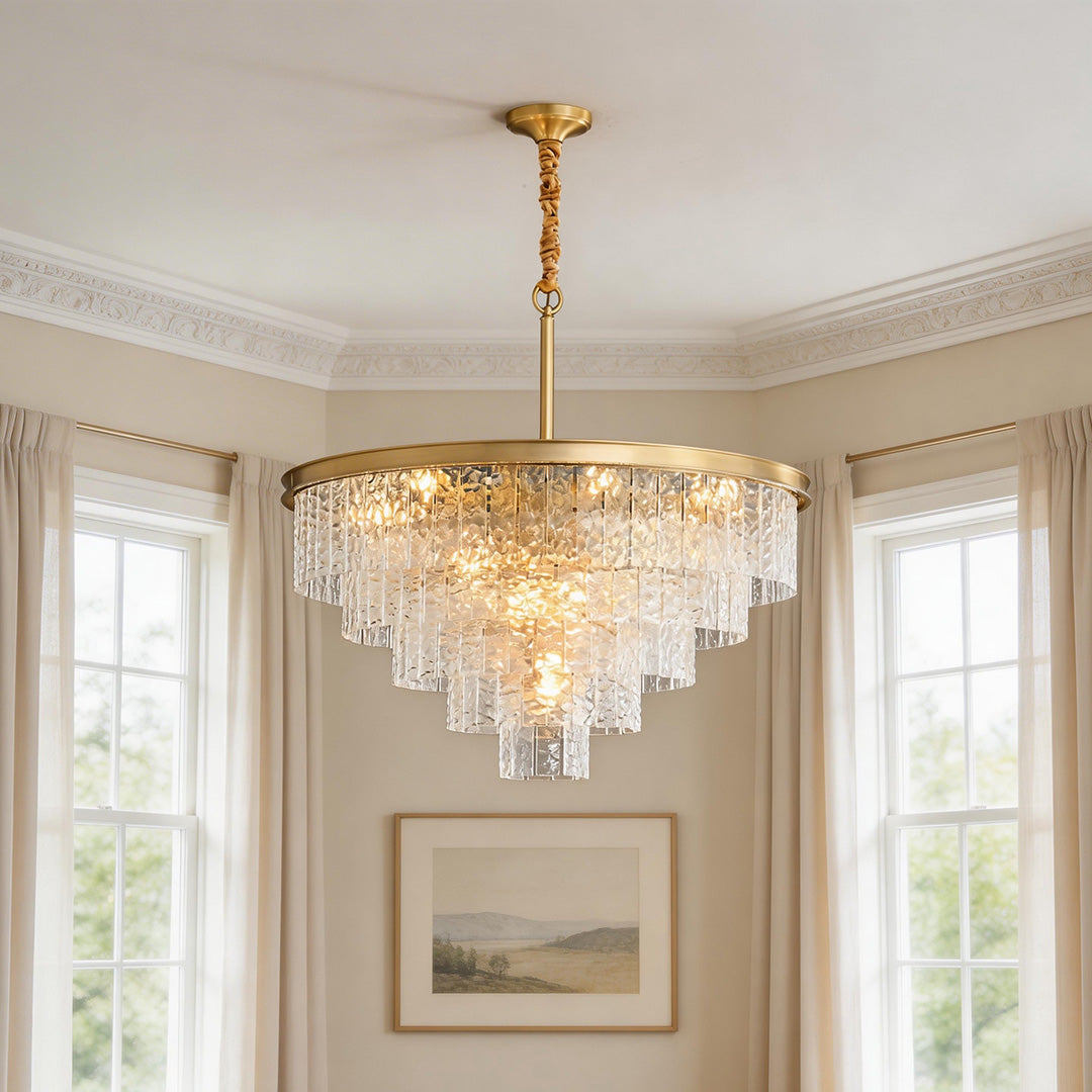 Elegant tiered modern forms chandelier featuring textured glass elements and a gold frame in a bright living space.