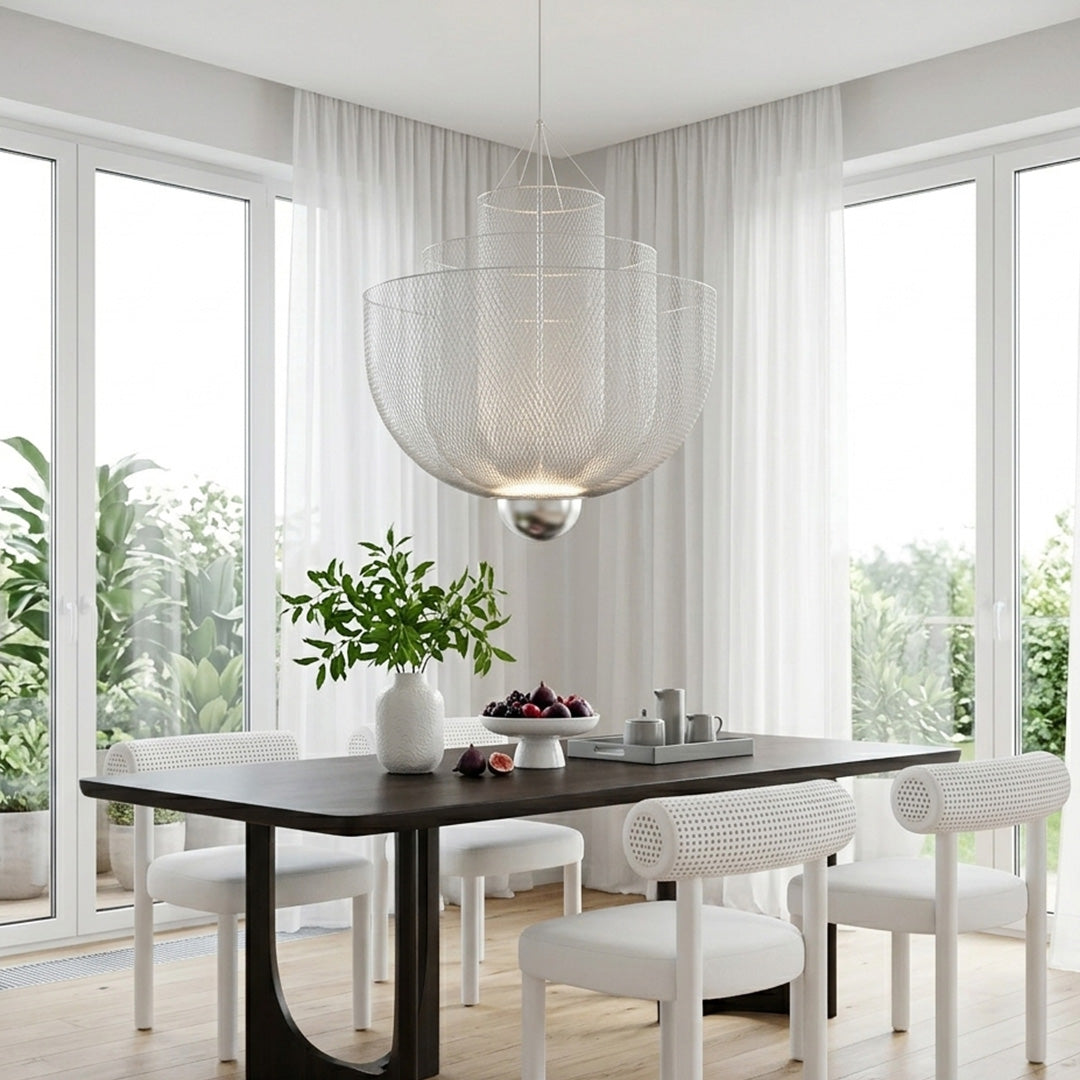 Tiered silver mesh chandelier above a dark table with white chairs and a garden window view.