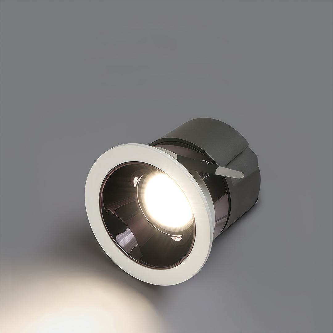 Tilting adjustable downlight demonstrating beam angle and warm light output on grey surface