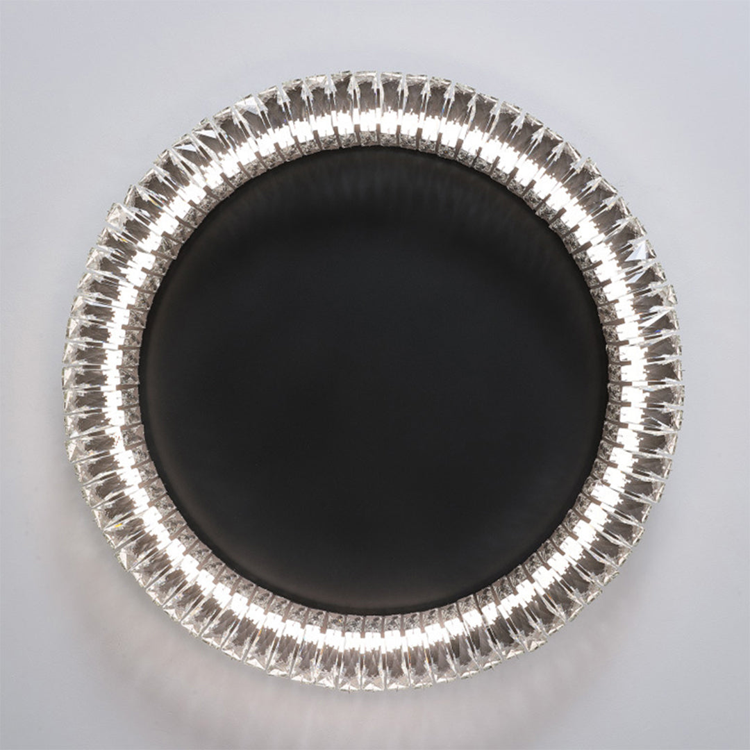 Top view of black ceiling flush mount light displaying circular pattern with central black disc and crystal border.