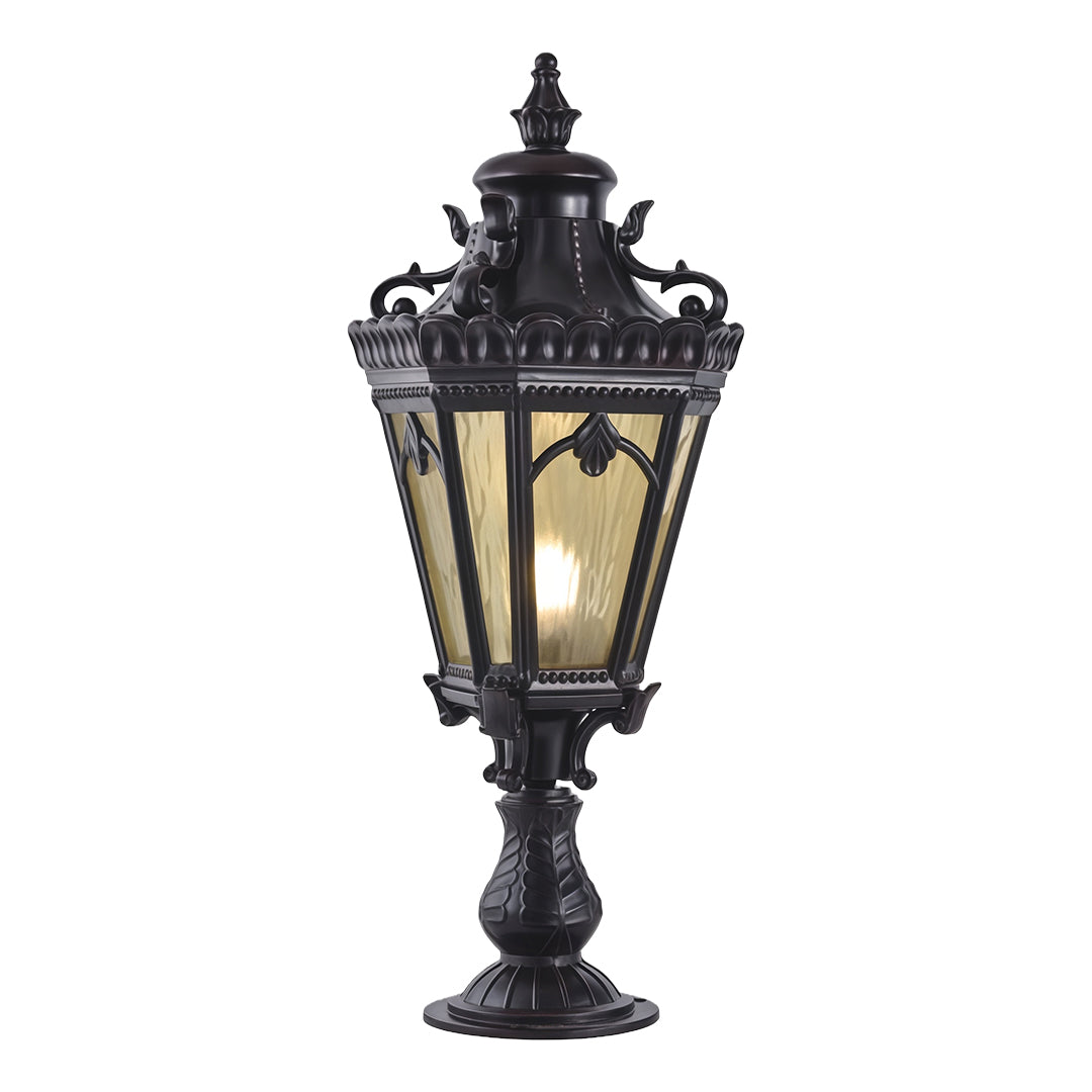 Traditional black outdoor pillar light featuring intricate decorative metalwork and amber glass on white background