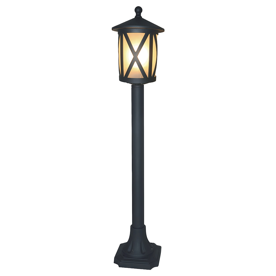 Traditional garden bollard light featuring crisscross glass design and dark finish on white background