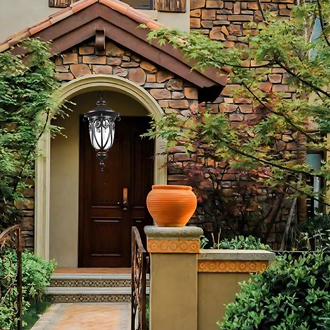 Traditional lantern illuminating brick archway entrance with wooden door and garden setting