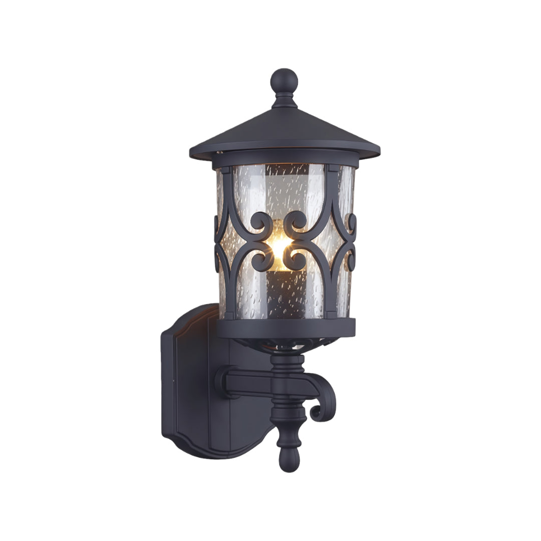 Traditional outdoor black sconce featuring ornate cutout design and amber glass against white background