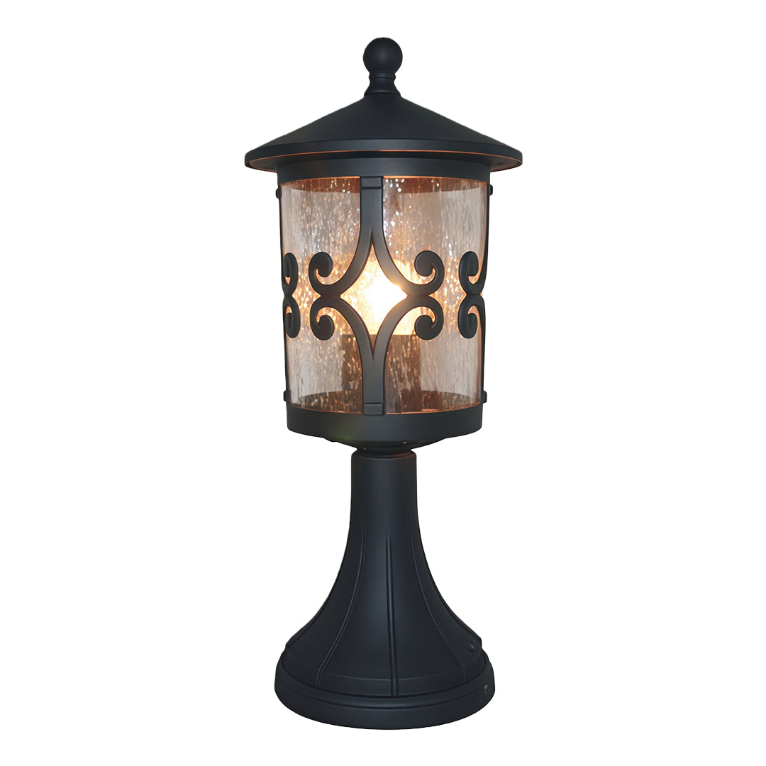 Traditional porch pillar light featuring intricate scrollwork design and amber glass in dark metal finish