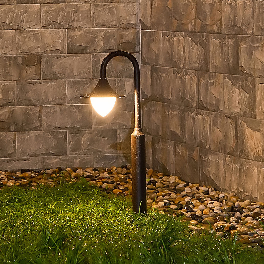 Traditional landscape lighting featuring shepherd's hook fixtures against natural stone wall backdrop