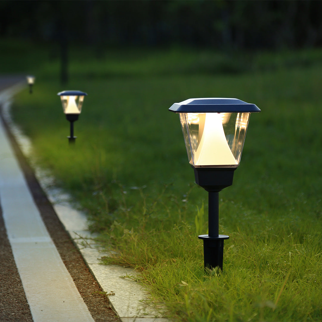 Traditional solar garden lights illuminating lawn area with warm white LED lighting at dusk