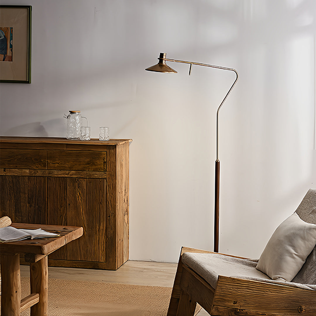 Traditional vintage gold floor lamp with adjustable head creating cozy atmosphere in bedroom with wooden furniture