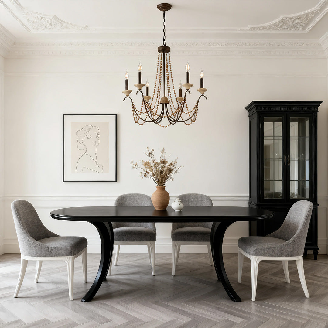Traditional French style chandelier with a wrought iron appearance, perfectly centered above a modern curved dining table in a bright room.