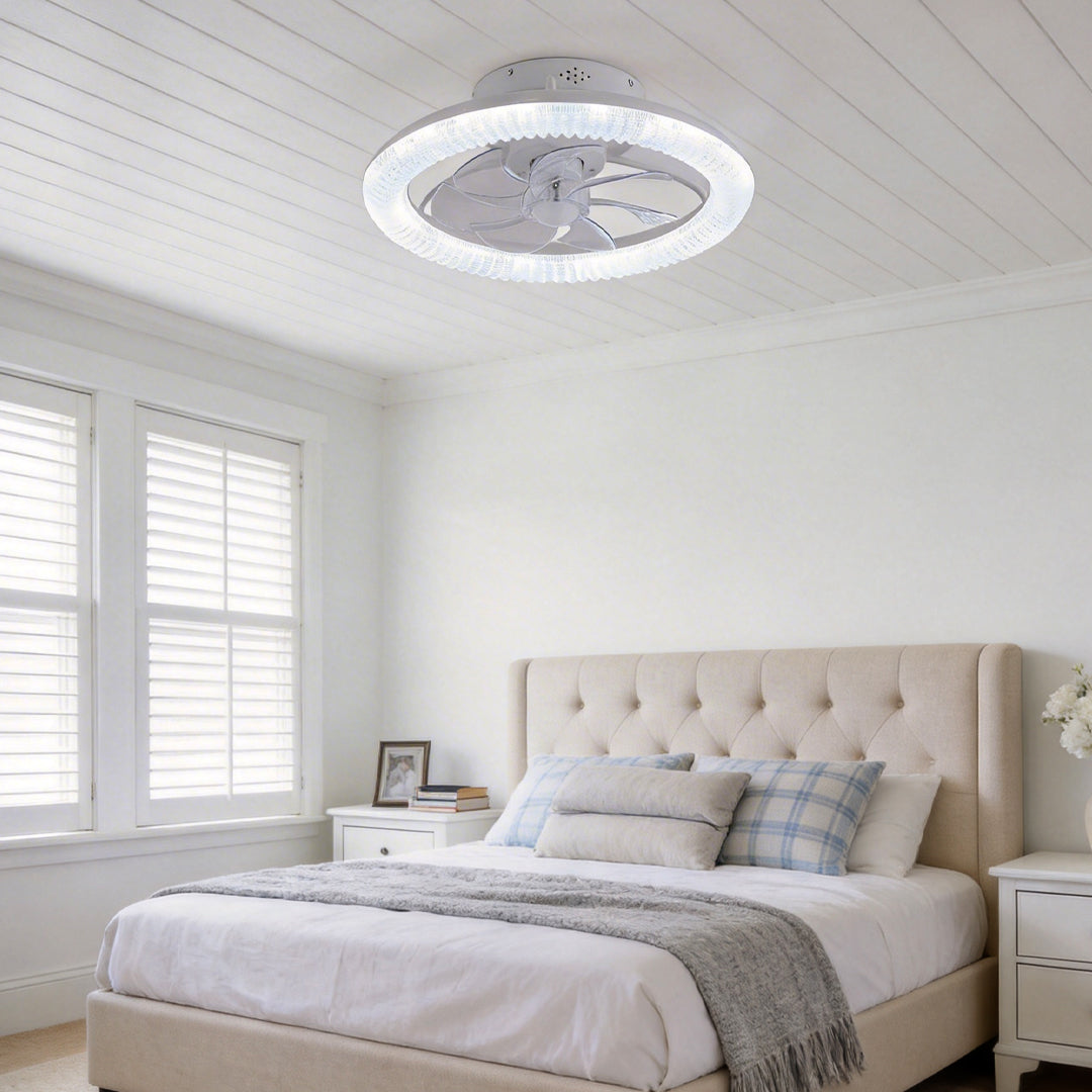 Transparent blade ceiling fan with light, providing illumination in a contemporary bedroom.