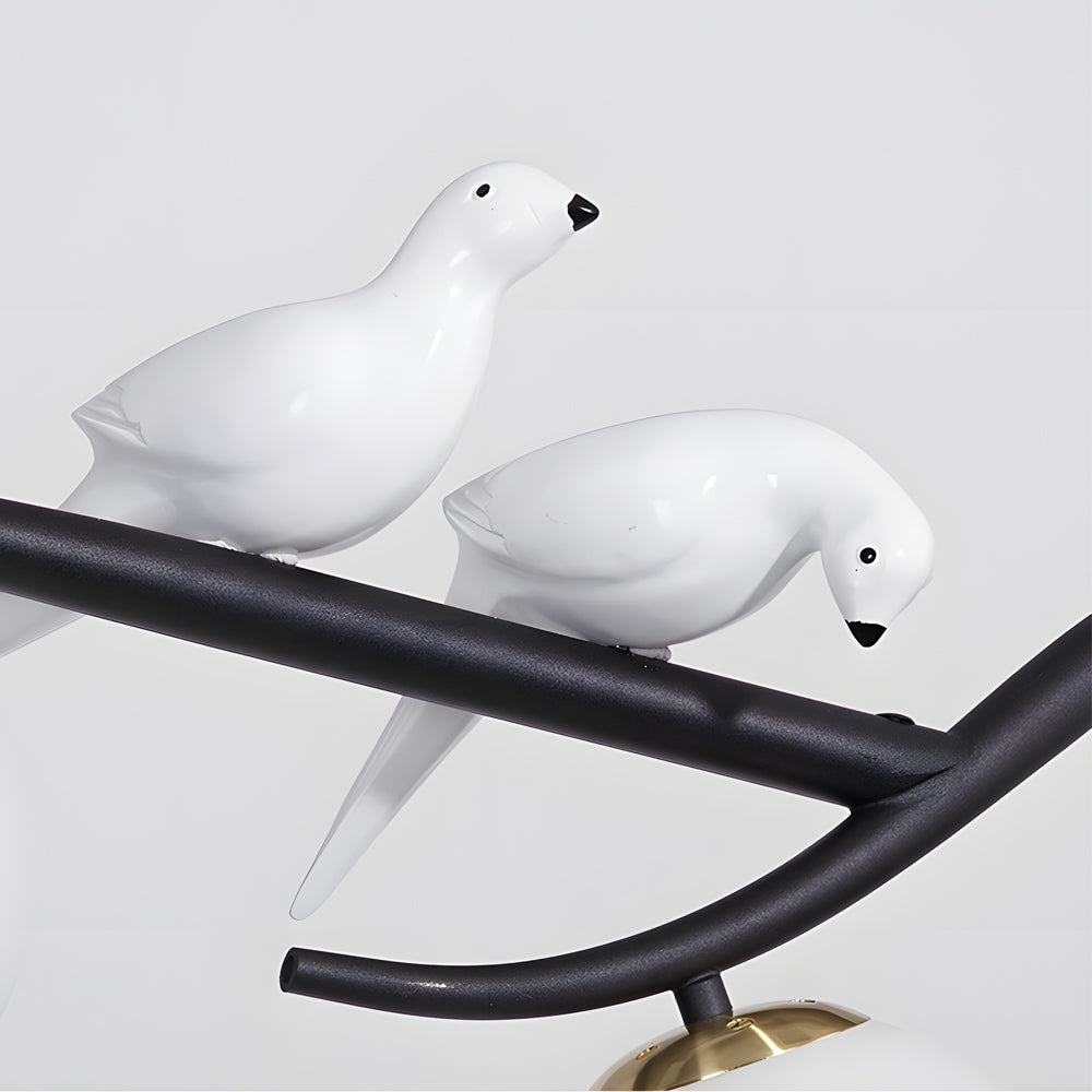 Decorative bird detail on tree branch pendant light fixture.