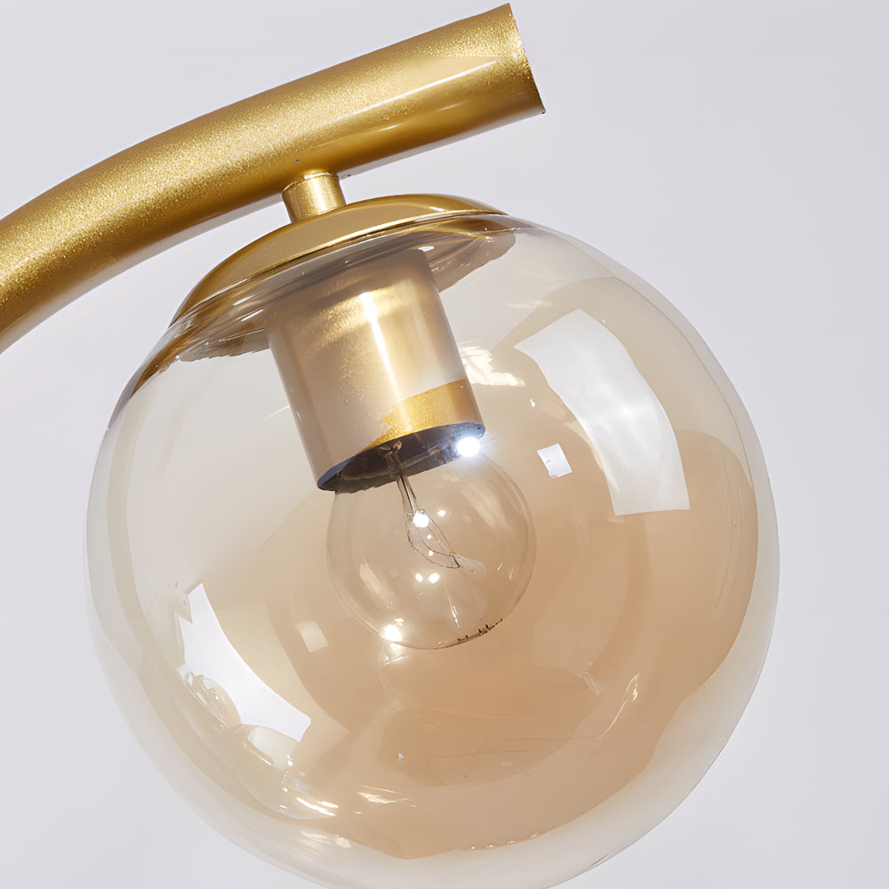 Close-up of glass globe shade on tree branch pendant light.